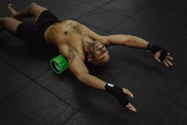 Top 10 Must-Have Gym Equipment and How to Effectively Use Them 10 Man lying with a foam roller on his back