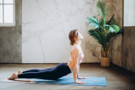 Top 10 Must-Have Gym Equipment and How to Effectively Use Them 9 Woman in pink sports bra and black leggings doing yoga on yoga mat