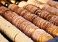 Budapest is always filled with the delicious aroma of chimney cake, a favorite treat throughout the year and especially beloved during the winter. This pastry is a highlight at Christmas markets in the city, known for its irresistible sweetness and best enjoyed warm, straight from the oven. Trying a chimney cake Budapest offers not just a delightful snack but a memorable experience. This cherished pastry, hailing from Transylvania, is usually coated with sugar and spices like cinnamon, vanilla, cocoa, or nuts. However, many stalls in Budapest have put their own twist on the classic, offering innovative versions such as chimney cakes shaped like cones and filled with ice cream or Nutella, or even split in half and topped with sweet or savory ingredients. Prepare your taste buds for an exciting journey through the world of chimney cake Budapest! Hungarian chimney cake – the origin of this fine dessert Chimney cakes, known as kürtőskalács in Hungary, are named for their chimney-like appearance, featuring a crispy exterior and a soft, sweet interior. They are traditionally made from a sweet dough that's wrapped around a spit and cooked over charcoal until it turns golden-brown, with the sugar-coating caramelizing to perfection. However, chimney cakes weren't always a sweet treat. This pastry, often hailed as one of Hungary's oldest, was first mentioned in a German document during the Middle Ages. By the 15th century, it was described as dough that was rolled out, then cooked on a rotating spit to form its distinctive spiral shape. Chimney cakes have evolved significantly over time, taking on various shapes and flavors across Central and Eastern Europe, known as 'trdelnik' in Slovakia and 'trdo' in the Czech Republic. Originating from Transylvania, the earliest known recipe for chimney cake dates back to 1784 and initially didn't include any sweeteners. The addition of sugar and almond coatings came later. Chimney cake Budapest – the best places to try this sweet pleasure in the city Now that you're familiar with the background of chimney cakes, it's time to try some for yourself. Budapest has many wonderful cafés and stands offering delicious chimney cakes in a variety of shapes, sizes, and flavors. First, though, it's a good idea to begin with the traditional versions. Kurtos kalacs chimney cake: Molnár’s Kürtőskalács Café Molnár’s Café is a top choice for cake lovers on Váci Street. When you're in the mood for something sweet while exploring Váci Street, Budapest's main shopping area, make your way to Molnár’s Kürtőskalács Café near Fővám tér. Offering both indoor and outdoor seating, this café provides eight delicious flavors of chimney cakes throughout the entire year. Once you try a chimney cake here, you'll definitely want to return for another taste of this delightful Hungarian specialty! One of the best kürtőskalács in the city at Vitéz Kürtős’ When you're near Városliget (City Park), Széchenyi Bath, or the Budapest Zoo, make sure to stop by Vitéz Kürtős' Sweet Bear chimney cake shop. Alongside traditional toppings, they offer unique fruity options such as raspberry, strawberry, and blueberry for an extra special treat. Discover unique chimney cakes in Budapest – a memorable street food experience. We've touched on some unique versions of chimney cakes, such as those stuffed with ice cream or made in vibrant colors, but there's much more to explore. Massage Budapest – another way of relaxation Dive into the ultimate relaxation experience in Budapest, where you're invited to indulge in unparalleled massage therapies. Budapest presents the finest selection of massages from across the globe, designed to rejuvenate both mind and body, ensuring a state of perfect tranquility. Budapest, a city bursting with endless delights, offers more than just its famed thermal baths and exciting water parks for those seeking aquatic adventures. Explore the vibrant nightlife, from iconic ruin pubs to chic rooftop bars and pulsating techno clubs. For those with a keen interest in culture, the city doesn't disappoint, with its rich historical landmarks, stunning vistas, and cultural institutions offering a feast for the intellect. After a day filled with such diverse activities, or simply to take a well-deserved break, pamper yourself at one of the capital's premier massage establishments. In Budapest, massage experiences are diverse, grouped into four main categories to cater to every preference for those in search of the perfect massage within the heart of Hungary. If you are interested in special treatments like sensual massage Budapest - this article is for you. We'll introduce you to the most sensual, pampering salons where you're sure not to leave unsatisfied. Massage Budapest – what choices do we have? So, about the 4 categories mentioned above: Massage offerings in Budapest's wellness spots: The variety of massage treatments available in Budapest's baths is impressive, covering everything from aromatic and rejuvenating massages to the classic Swedish and deep tissue techniques. Guests can also opt for specialized treatments like the gentle Breuss massage or targeted cellulite reduction therapies. Exploring Thai massage in Budapest: The city's landscape is dotted with numerous Thai massage centers, particularly noticeable around the central districts. This prevalence highlights a unique aspect of Budapest's wellness culture, with many of these centers offering easy-to-book sessions that cater to both spontaneous and planned visits. Cultural massage experiences in Budapest, Hungary: Among the massage options, there are treatments deeply embedded in cultural practices, including traditional Indian and Hungarian techniques. While predominantly found in Budapest, these authentic experiences are also accessible in smaller towns and are a staple in some boutique bathhouses. Specialized erotic massage Budapest: A segment of the Budapest massage market is dedicated to providing services primarily for a male audience, with some establishments specializing in erotic massages. Notably, even within some Thai massage parlors in the city, there exists the provision for massages with a 'happy ending', catering to those seeking an adult-oriented relaxation experience. About Rudas Baths, Gellért Baths, Lukács Baths and Széchenyi Baths At the Rudas Baths, uniquely home to Budapest's sole outdoor panoramic pool, a variety of massages are offered to visitors. Access to these indulgent treatments requires the acquisition of an entry pass, priced at 25 euros during the week and 32 euros for weekend visits. Meanwhile, the Gellért Baths stand out as one of Hungary's most stunning thermal bath complexes, where guests can choose from an array of massages, including aromatic options. Entry to this exquisite facility, and thereby access to its massage services, necessitates the purchase of an admission ticket, costing 28 euros on weekdays and 32 euros on weekends. Over at the Lukács Baths, visitors can find some of the most affordably priced massages in Budapest. To partake in these services, one must first buy a bath entry ticket, which is available at 13 euros on weekdays and 14 euros on weekends, making it an attractive option for budget-conscious visitors. Trdelnik - grilled rolled dough, Czech hot sweet pastry